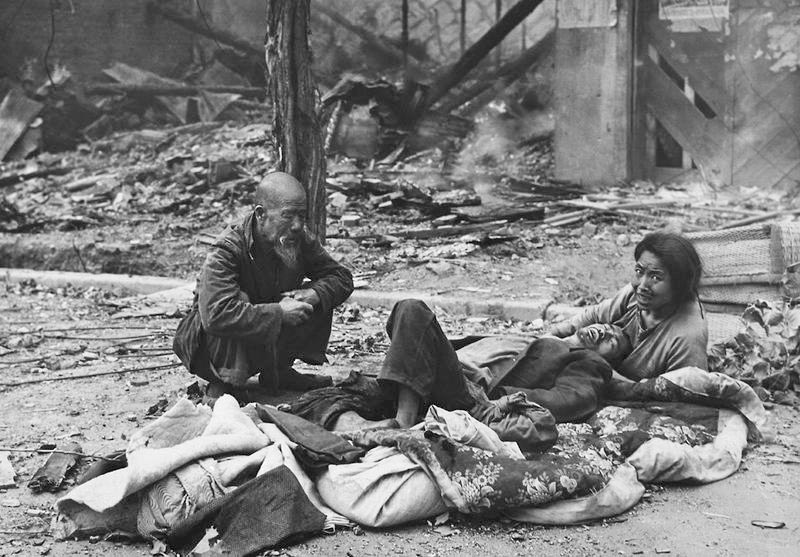 Корейцы лежат на улице среди обломков после военных действий в Сеуле в сентябре 1950 года